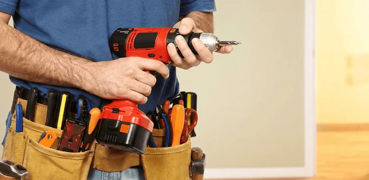 Handyman holding a power drill for home repairs and installations in Akron, OH